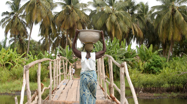 Afrikanische Frau trägt Wasserbehälter auf dem Kopf